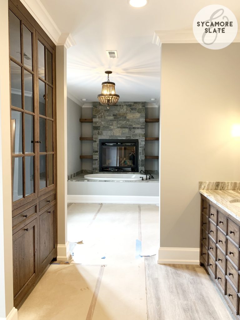 master en suite bathroom with vanity,built in linen cabinet, bathtub and fireplace shown